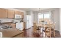Cozy kitchen area featuring wood cabinets, white appliances, and access to outdoor patio at 5530 Lewiston Ct, Denver, CO 80239