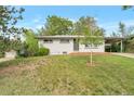 Inviting home featuring a well-maintained lawn, a mature tree, and a painted white brick exterior at 8280 Auburn Ln, Westminster, CO 80031