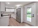 Well-lit kitchen featuring stainless steel appliances, white cabinets and a view to the backyard at 8280 Auburn Ln, Westminster, CO 80031