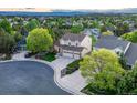 Aerial shot of a property highlighting its well-manicured lawn, a three-car garage, and neighborhood at 6973 Daventry Pl, Castle Pines, CO 80108
