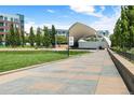 Open-air amphitheater in a park with green grass, tall trees, and paved walkways under a blue sky at 7700 E 29Th Ave # 404, Denver, CO 80238