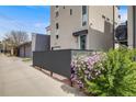 Contemporary home exterior with a well-manicured yard featuring mature shrubs and a gated drive leading to a detached garage at 2607 W 24Th Ave, Denver, CO 80211