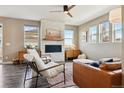 Bright living room features a fireplace with stone accent wall, ceiling fan, and lots of natural light at 5687 Dayton St, Denver, CO 80238