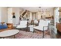 Open concept living room with a staircase, dining area, and bright kitchen in the background at 5687 Dayton St, Denver, CO 80238