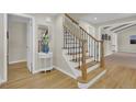 Elegant staircase with wooden treads, wrought iron balusters and a matching wooden handrail at 7504 E Jefferson Dr, Denver, CO 80237