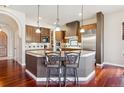 Stylish kitchen featuring an island with barstool seating, pendant lighting, and stainless steel appliances at 4775 S Anaheim Ct, Aurora, CO 80015
