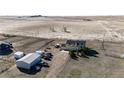 A rural residence with outbuildings, several vehicles, and bordering a large vacant field at 7440 S Shenandoah Dr, Elizabeth, CO 80107