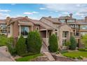 An exterior view of the home with stone and stucco facade and manicured lawn at 9228 Sori Ln, Highlands Ranch, CO 80126