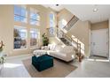 Bright living room with high ceilings, large windows, a modern staircase, and stylish decor at 9228 Sori Ln, Highlands Ranch, CO 80126