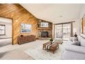 Comfortable living room with stone fireplace, wood accent wall, and sliding glass doors leading to a balcony at 7790 W 87Th Dr # H, Arvada, CO 80005