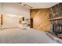 Open concept living area with a stone fireplace and wood accent wall, great for entertaining at 7790 W 87Th Dr # H, Arvada, CO 80005