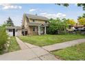 Inviting two-story home with a detached garage, featuring a well-manicured lawn and a welcoming neighborhood ambiance at 1551 S University Blvd, Denver, CO 80210