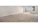 Spacious living room with carpet, natural light and a sliding door that leads to the outdoor balcony at 11250 Florence St # 29D, Commerce City, CO 80640