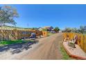 Long gravel driveway leads to a charming ranch home with rustic accents at 1641 Castlewood Dr, Franktown, CO 80116