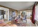 Spacious living room features stone accent wall and comfortable seating at 1641 Castlewood Dr, Franktown, CO 80116