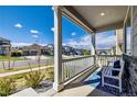 Inviting covered front porch with a white railing and seating area, perfect for relaxing outdoors at 17341 Red Cosmos Pt, Parker, CO 80134
