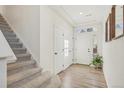 A modern entryway with a staircase, white doors, and light hardwood flooring at 18372 E 100Th Pl, Commerce City, CO 80022