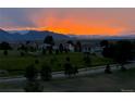 Stunning sunset over rolling green hills, houses, and mountains, promising breathtaking views and a serene neighborhood at 3223 Castle Peak Ave, Superior, CO 80027