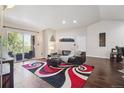 Open-concept living room featuring hardwood floors and a balcony at 875 E 78Th Ave # 7, Denver, CO 80229