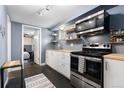 Galley kitchen with stainless steel appliances and white cabinets at 1310 N Corona St # A, Denver, CO 80218