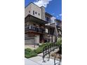 Multi-level modern home with balconies, stone accents, and landscaped entry, presenting a stylish facade under a bright sky at 1004 Maria Ln, Louisville, CO 80027