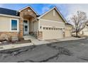 Attractive exterior with a stone facade, three-car garage, and well-maintained landscaping at 6606 S Reed Way # B, Littleton, CO 80123