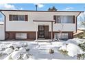 Ranch style home with snow-covered landscaping at 995 S Upham St, Lakewood, CO 80226