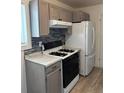 Cozy kitchen with gas range stove, white refrigerator, and grey cabinets and backsplash at 7620 Kearney Dr, Commerce City, CO 80022