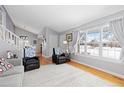 Bright living room with hardwood floors, neutral walls, large windows, and a staircase, creating an open and airy atmosphere at 1606 S Flanders Way, Aurora, CO 80017