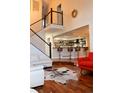 Open living room with wood floors, staircase, and a kitchen view at 8747 Mesquite Row, Lone Tree, CO 80124