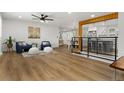 Open concept living room featuring hardwood floors, natural light, modern decor, and a partial view of the kitchen at 9197 W Woodard Dr, Lakewood, CO 80227