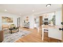 Open-concept living room with hardwood floors and a view to the kitchen and dining area at 1892 S Fairfax St, Denver, CO 80222