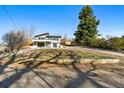 Well-maintained property showcasing a landscaped yard, two-car garage, and a distinctive architectural style at 5390 Rosemary Ln, Denver, CO 80221