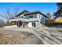 Beautifully landscaped home featuring a two-car garage, a balcony, stone accents, and a spacious driveway at 5390 Rosemary Ln, Denver, CO 80221