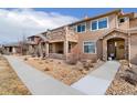 Attractive multi-story home with a stone facade and tidy landscaping with walkway leading to an arched entrance at 8627 Gold Peak Pl # C, Highlands Ranch, CO 80130