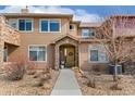 Charming two-story condo with a stone-accented entrance and well-manicured landscaping leading to the front door at 8627 Gold Peak Pl # C, Highlands Ranch, CO 80130