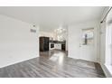 Bright living room with modern flooring that flows into the kitchen with black appliances at 1629 S Deframe St # A1, Lakewood, CO 80228