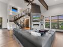 Inviting living room with a modern fireplace, open staircase, and large sectional sofa at 12947 Lazy Dog Ln, Littleton, CO 80127