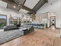 Open-concept living room flowing into a kitchen with a vaulted ceiling and exposed beams at 12947 Lazy Dog Ln, Littleton, CO 80127