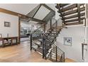 Modern staircase featuring metal railings and wood treads inside of a light-filled foyer at 12947 Lazy Dog Ln, Littleton, CO 80127