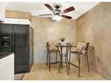 Eat-in kitchen featuring a black fridge and modern light fixture at 7755 E Quincy Ave # 206, Denver, CO 80237