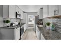 Updated kitchen featuring granite countertops and white cabinetry at 3550 S Harlan # 144, Denver, CO 80235