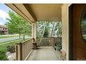 Relaxing front porch with views of the neighborhood and a comfortable seating area at 15348 W 75Th Pl, Arvada, CO 80007