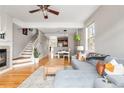 Open-concept living room with fireplace, staircase, wood floors, and cozy blue sectional couch at 5428 Zephyr Ct, Arvada, CO 80002