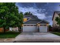Two-story home featuring a gray exterior, two-car garage, covered porch, and well-kept landscaping at 6358 S Miller Way, Littleton, CO 80127