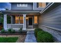 Inviting front porch with decorative columns, hanging plants, and manicured landscaping leading to front door at 6358 S Miller Way, Littleton, CO 80127
