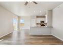 Bright, open-concept living space featuring wood-look floors, light walls, and a modern kitchen with stainless appliances at 48265 Shetland Dr, Bennett, CO 80102