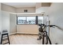 Versatile space with hardwood floors, a large window with a city view, and a bicycle parked inside at 100 Park W Ave # 201, Denver, CO 80205