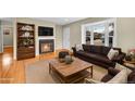 Bright, staged living room features hardwood floors, a fireplace, and a large bay window at 6990 Larsh Dr, Denver, CO 80221