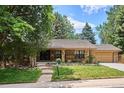 Lovely brick home with lush front yard and mature trees, offering great curb appeal at 7577 S Pierce Way, Littleton, CO 80128